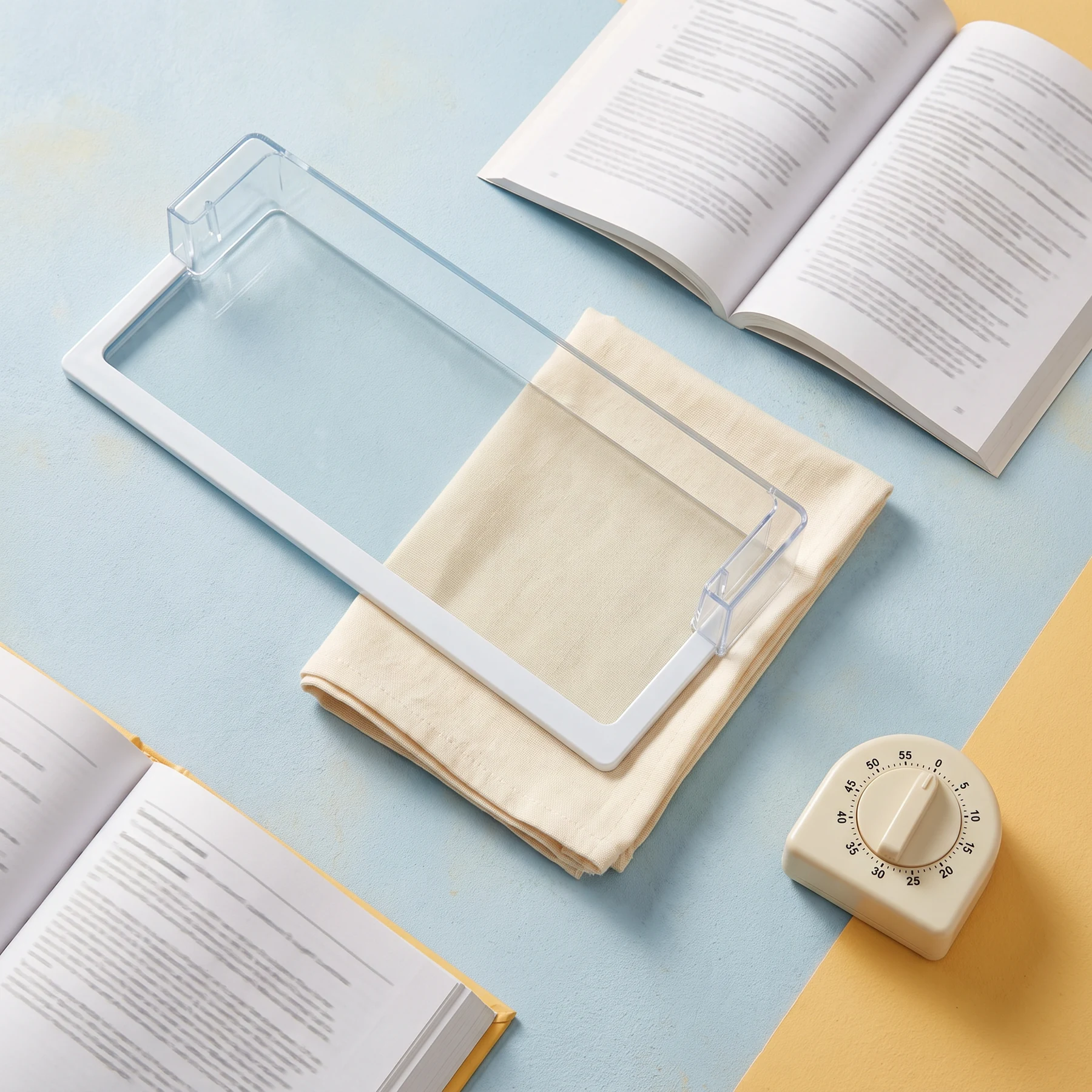 An open instruction book, notepad and calculator on a pale blue surface